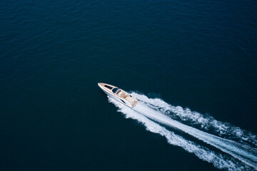 Expensive big open super high speed white boat with people moving on water top view. Speedy white...