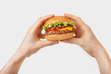 burger with cheese and beef in male hands on a white background