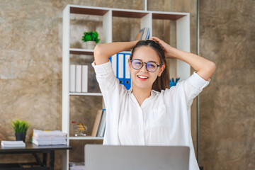 Happy young businesswoman using laptop computer doing online shopping, Smiling beautiful Asian woman sitting and working at workplace.