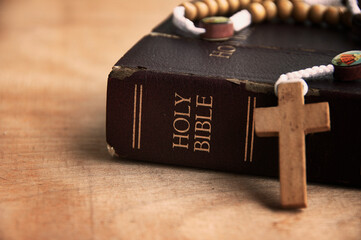 Holy Bible and Rosary on a wooden table with customizable space to add ideas or text. Christianity...