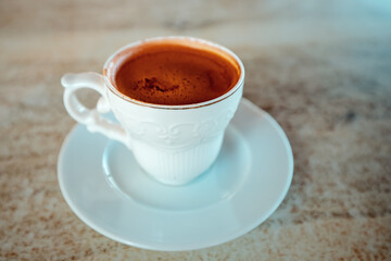 Strong coffee in a porcelain cup on the table in the cafe. An invigorating and flavorful decaf drink