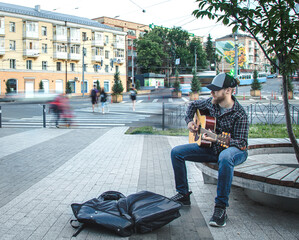 Male street musician plays the acoustic guitar.