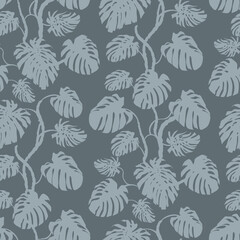 Seamless monochrome pattern with silhouettes of monstera leaves in gray shades for textile and surface design
