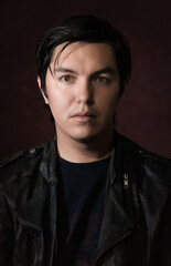 Obraz premium young hispanic man with black jacket and red wine background portrait classic art 