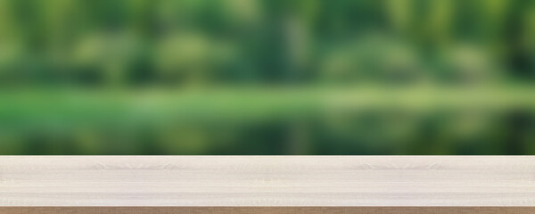 empty table on a blurry natural green background. tabletop.