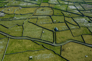 Green grass fields between stone fences of walls. Aerial top down view on meadow. Irish landscape....