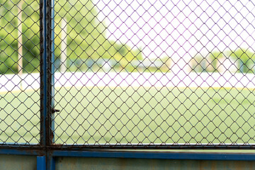 Protective fence with a rusty lattice around the football field.
