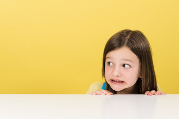 Closeup portrait of scared little girl looking at yellow copy space
