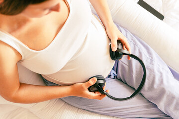 Pregnant woman music listen. Cheerful pregnancy girl relaxing listening music in headphones. Mother belly listen headphones sound. Pregnancy, medicine health care and people concept.