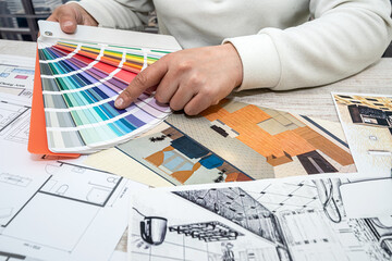 view of a man working on the design of the apartment according to the finished drawing.