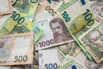 Fototapeta na wymiar Top view of various euro and Ukrainian hryvnia banknotes on a spacious table.