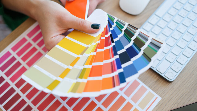 Interior designer holding fan of colourful samples in hand