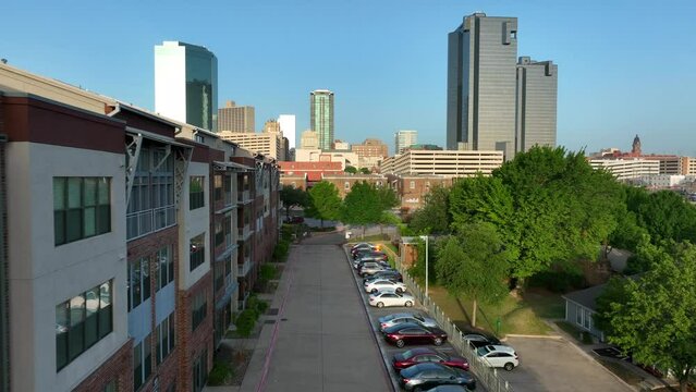 Fort Worth Texas skyline. Residential apartment building and car parking. Aerial pullback reveal shot. Modern renovated repurposed housing.