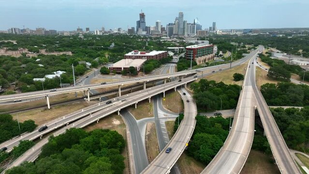 Population and traffic growth in Austin Texas. City skyline in distance. Aerial pullback reveal of busy metropolis in TX USA.
