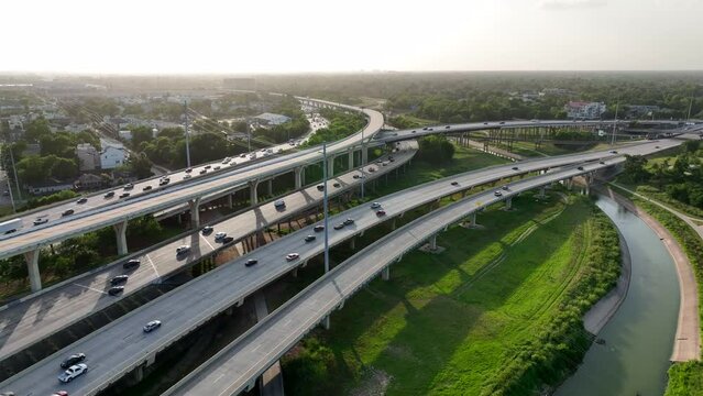 Traffic on interstate in Texas. Bridges over river water. Warm golden hour sunset.
