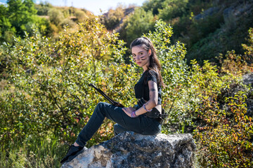 Sexy woman in top holing gun rifle wild nature