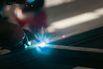 Industry worker welding iron pieces at work