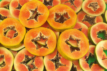 Red and orange papaya fruits slices close up