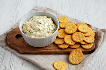 Homemade Caramelized Onion and Spinach Dip with Salty Round Crackers, side view.
