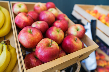 Healthy fruit and vegetables in grocery shop. Close up of basket with apples in supermarket.