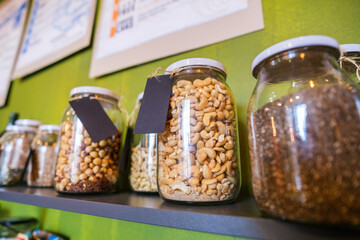 Close up image of jars with cashew and other seeds in vegan food shop.