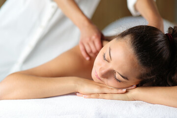 Fototapeta na wymiar Woman relaxing with therapist massaging in spa