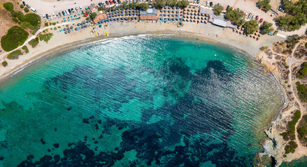 Panoramic aerial top view of the emerald sea at the popular Mavro Lithari beach at Saronida, Attica, Greece