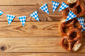 Oktoberfest concept with pretzel and blue simbol flag on wood background