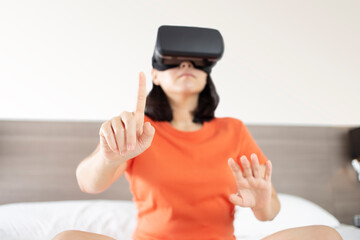 Metaverse Technology concepts. Young women wearing virtual reality glasses in modern interior design touch virtual screen flares effect, blurred background