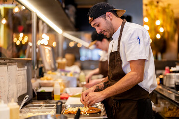 Smiling man preparing food at restaurant kitchen