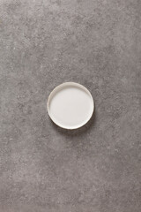 Empty vintage white plate on gray concrete empty background. Food and cooking concept, copy space for text or advertisement