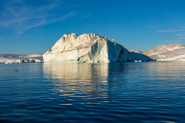 Fototapeta na wymiar Huge iceberg reflecting in a calm sea, Disko Bay, in the vicinity of Ilulissat Greenland