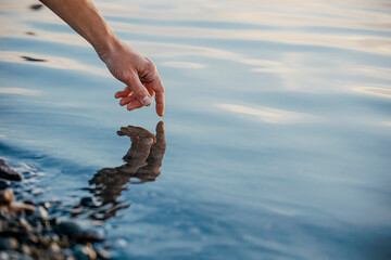 Hand of man touching water
