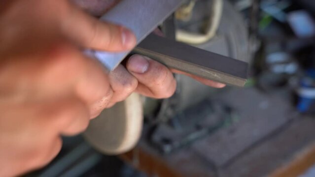 sharpening a kitchen knife on a grinding diamond bar. workshop. professional sharpening