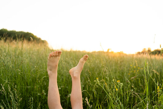 Girl with feet up in field