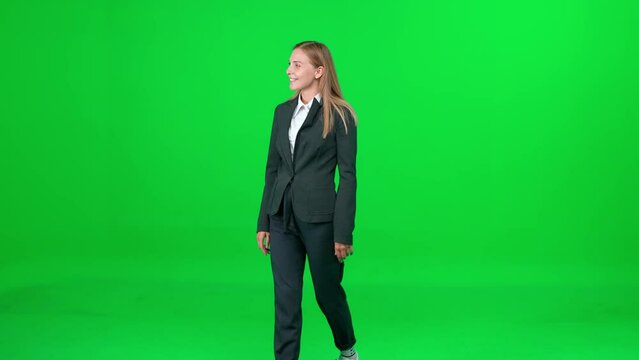 Businesswoman in a suit walking down the street on a green background, a elegant passerby on a walk, chroma key template.