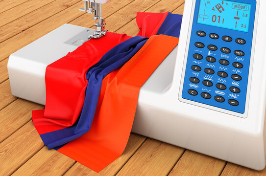 Sewing machine with Armenian flag on the wooden table. 3D rendering
