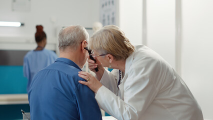 Otolaryngology specialist using otoscope to examine ear infection, helping patient with disease....