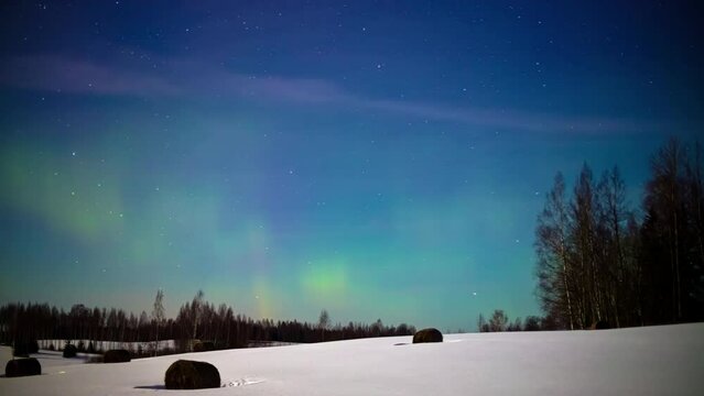 The northern lights aurora borealis and stars cross the winter sky in this dreamy time lapse