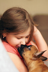 Obraz premium Little girl holding adorable cute little pet French bulldog puppy.