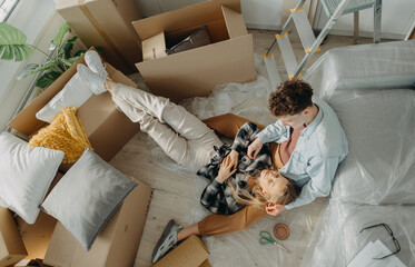 Top view of cheerful young couple in their new apartment. Conception of moving.