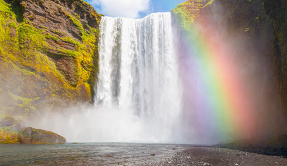 Fototapeta na wymiar Icelandic Landscape concept - View of famous Skogafoss waterfall and amazing rainbow