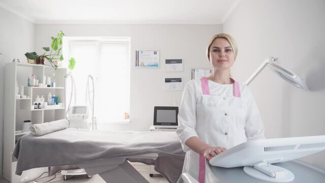 A cosmetologist smoothes out wrinkles with microcurrent. Hardware procedure in cosmetology. Peeling, phonophoresis, massage and face lift in a cosmetic clinic. The doctor accepts in the office.