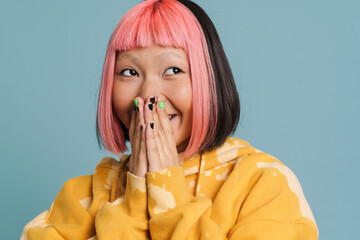 Asian girl with pink hair laughing and covering her mouth