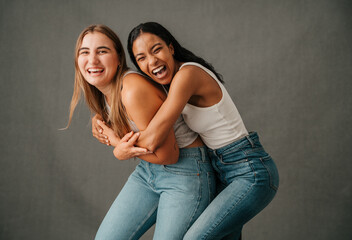 Two female friends smiling and laughing playing around and having fun