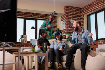 Diverse group of friends celebrating video games victory, winning game with augmented reality goggles on tv console. People using vr glasses to win competition at house party, leisure activity.