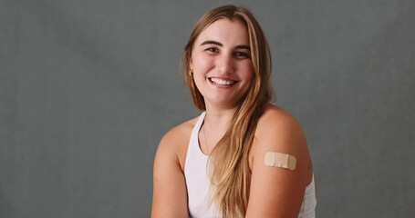 Caucasian female looking at her injured arm with a band aid on