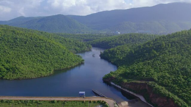 Aerial landscape with green hills, river dam and forest