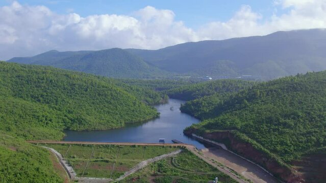 Aerial landscape with green hills, river dam and forest