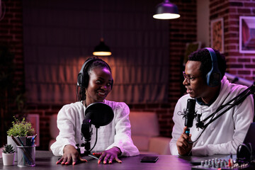 Happy content creators chatting on podcast talk show, recording live content with sound equipment...